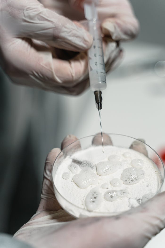 The Art of Drawing Readers In: Your attractive post title goes here Close-up of hands in gloves using syringe in laboratory setting.